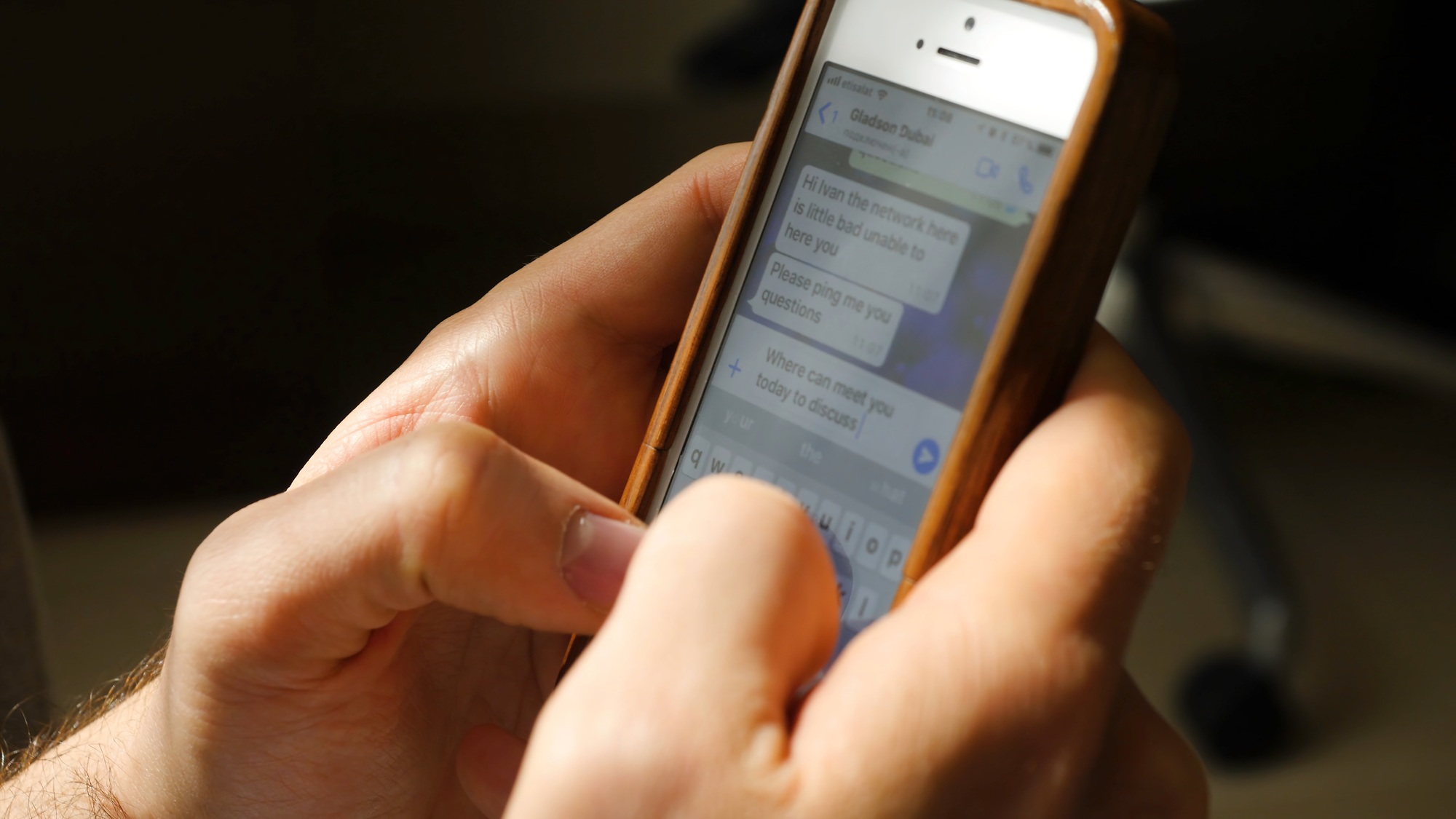 Man sending or reading sms on his mobile phone. Closeup of man typing a message on mobile phone. The