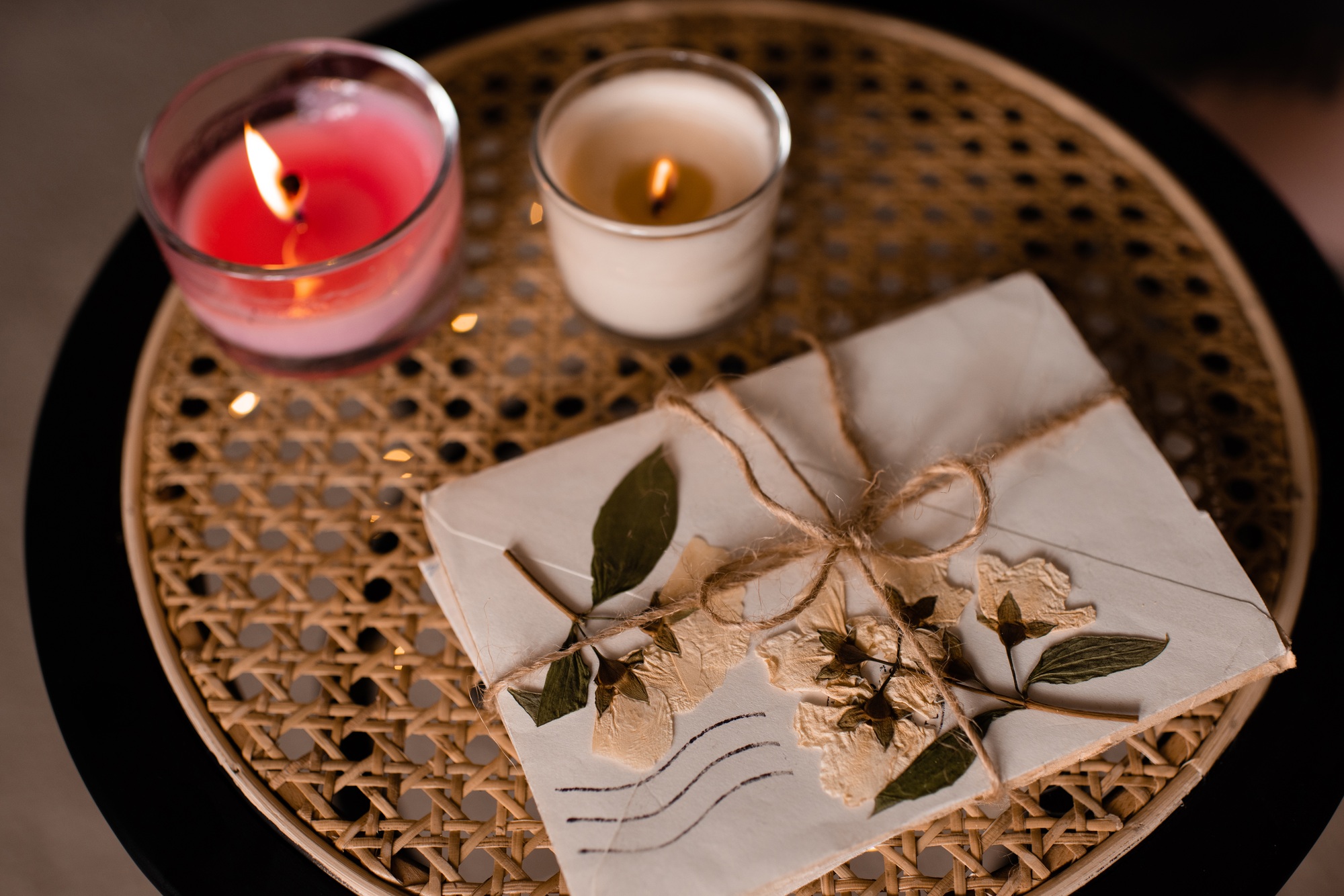 Old vintage love letters with burning candle on rattan table