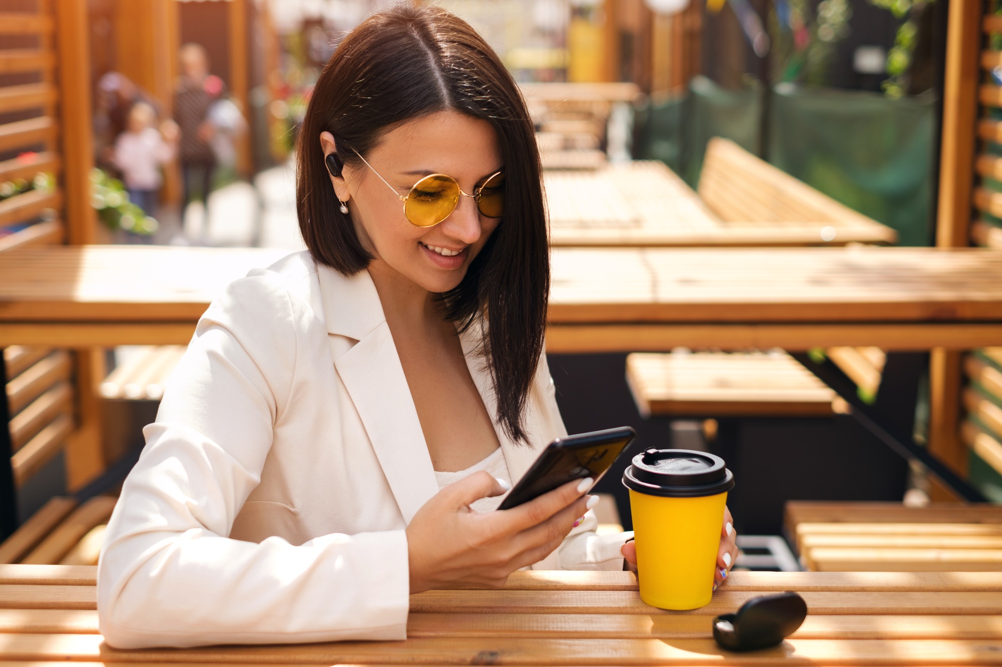 A woman writing messages in her smartphone and listening to music