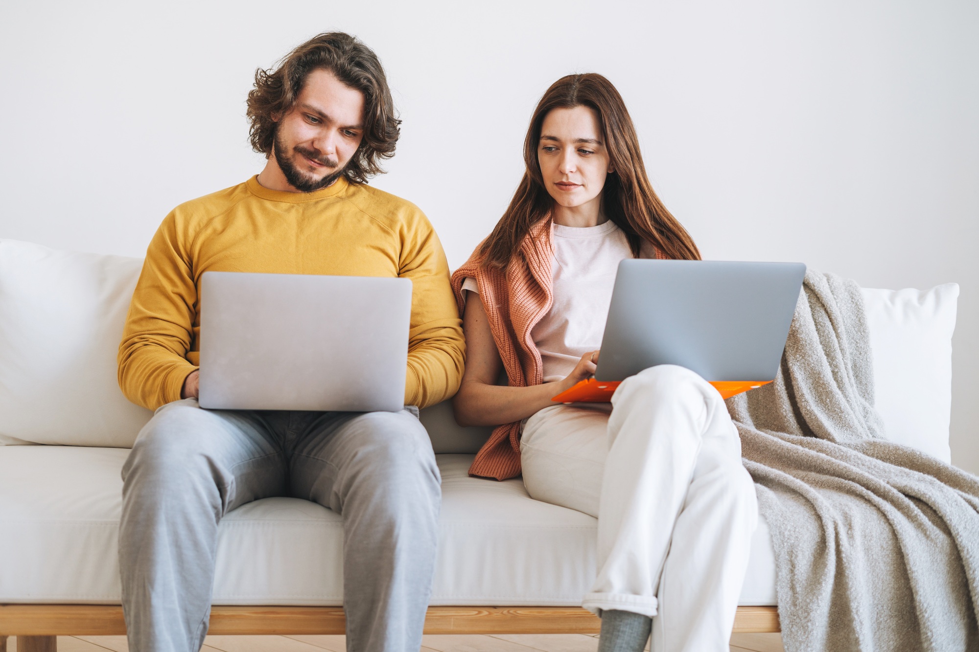Happy couple young family using laptop on sofa in living room at home