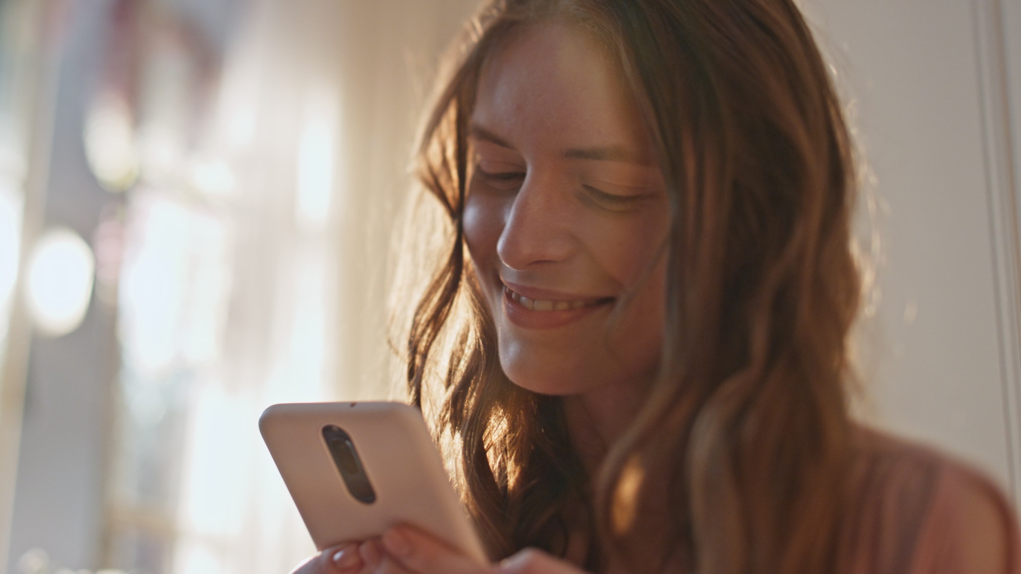 Joyful girl reading message sms in sunlight closeup. Happy teenager using mobile