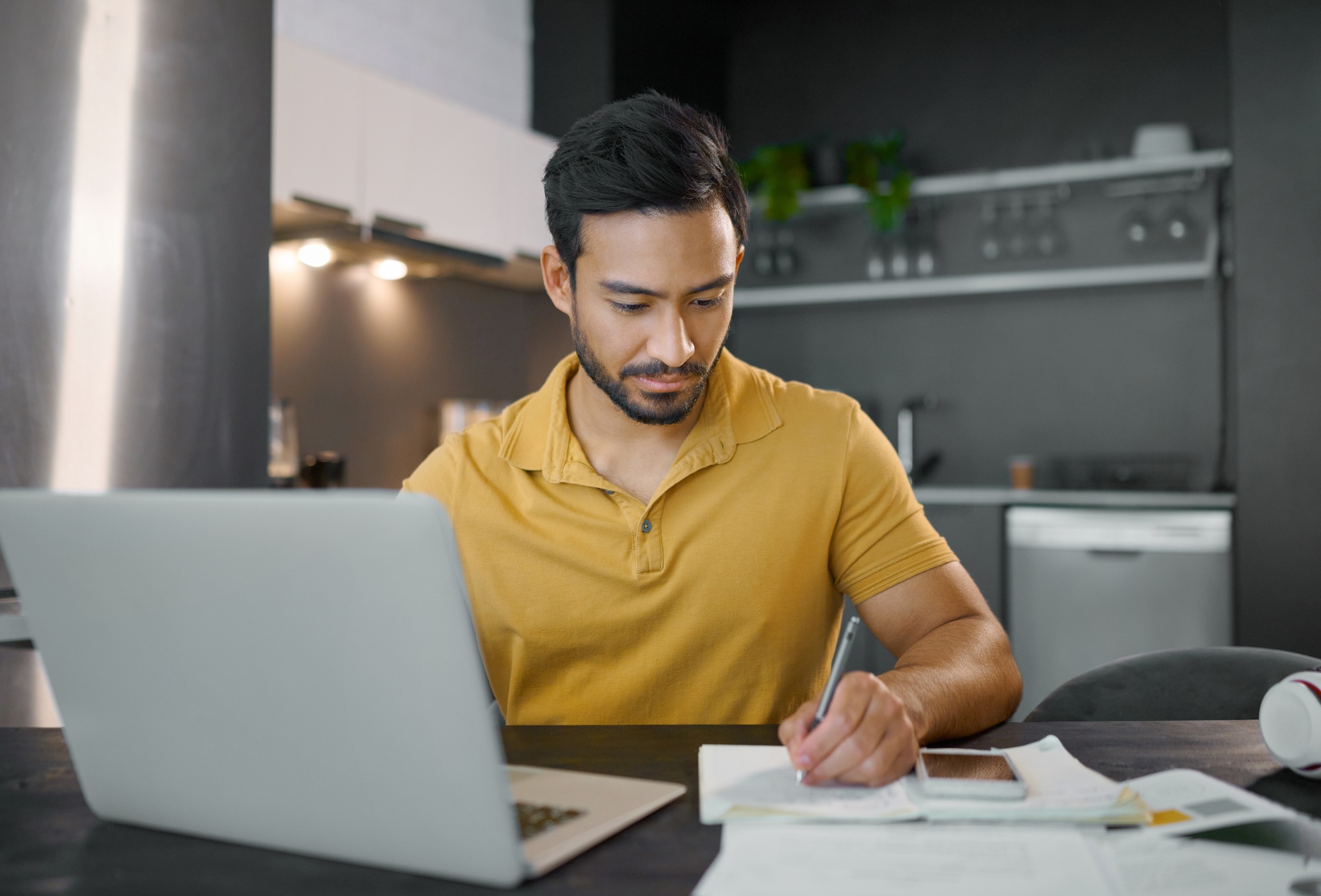 Laptop, writing and notebook with a freelance man doing remote work from home on research in his sm