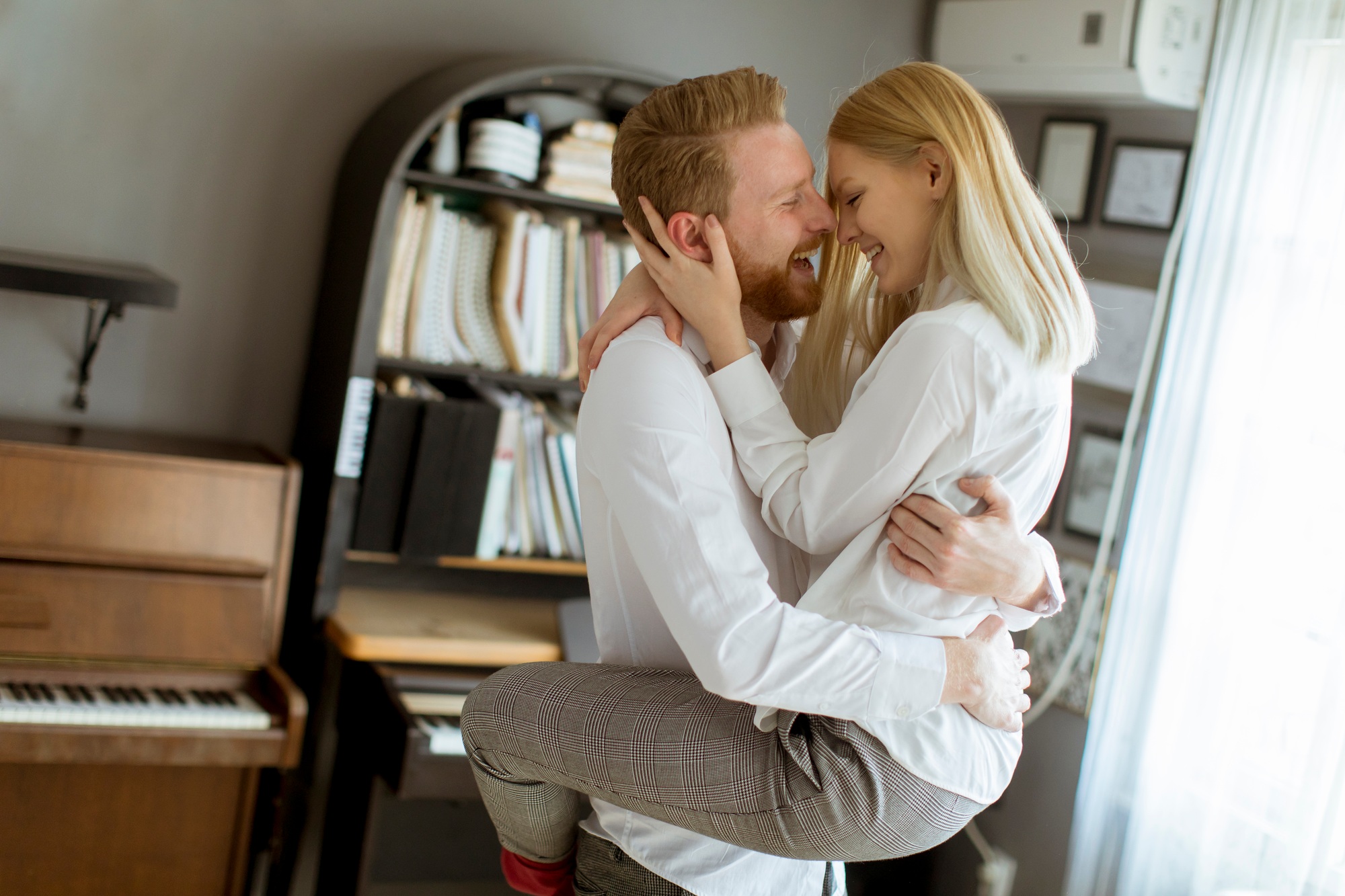 Loving young couple kissing in the room