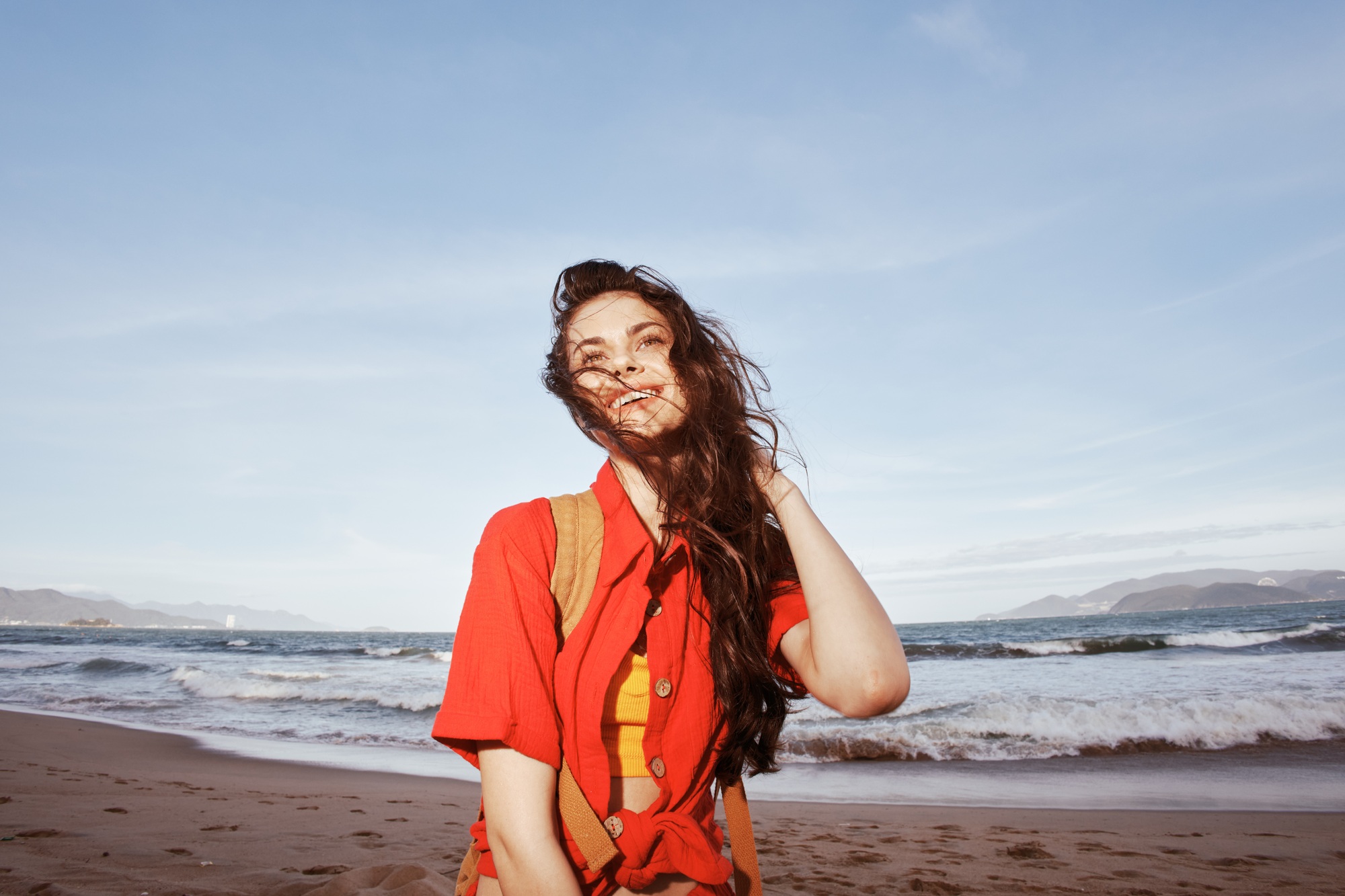 Sun-Kissed Freedom: A Joyful Woman Embracing Life by the Blue Sea